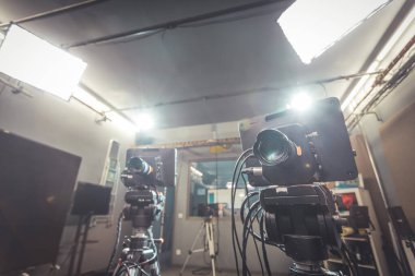 Televizyon stüdyosundaki erkek gazeteci mikrofona, film kameralarına konuşuyor.