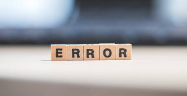 Harfli tahta küpler. Hata dizüstü bilgisayarda yatıyor..