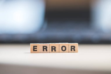 Harfli tahta küpler. Hata dizüstü bilgisayarda yatıyor..