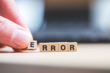 Harfli tahta küpler. Hata dizüstü bilgisayarda yatıyor..