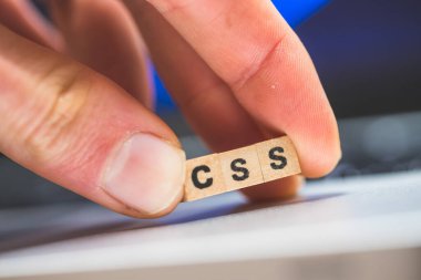 Üzerinde CSS harfleri olan tahta küpler dizüstü bilgisayarda yatıyor..
