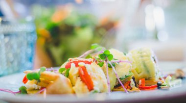 Yumurtalı omleti taze sebzelerle kapat. Beyaz seramik tabağa yerleştirilmiş.