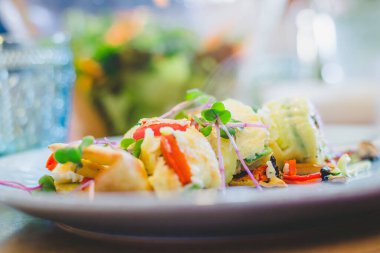 Yumurtalı omleti taze sebzelerle kapat. Beyaz seramik tabağa yerleştirilmiş.