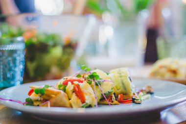Yumurtalı omleti taze sebzelerle kapat. Beyaz seramik tabağa yerleştirilmiş.
