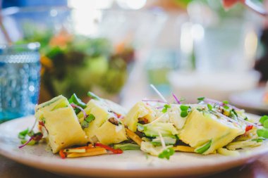Yumurtalı omleti taze sebzelerle kapat. Beyaz seramik tabağa yerleştirilmiş.
