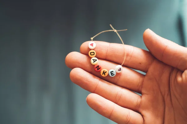 Close Van Hand Houden Van Een Armband Gemaakt Van Letters — Stockfoto