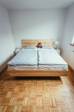 Yatak odasında büyük, rahat bir çam yatağı.