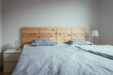 Yatak odasında büyük, rahat bir çam yatağı.