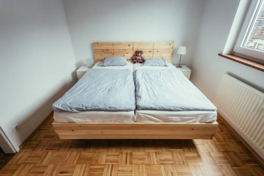 Yatak odasında büyük, rahat bir çam yatağı.