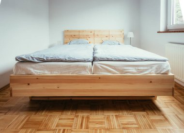 Yatak odasında büyük, rahat bir çam yatağı.