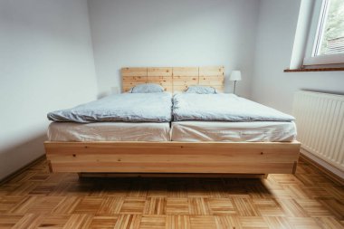 Yatak odasında büyük, rahat bir çam yatağı.