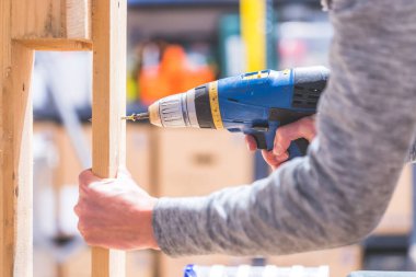 Bunu kendin yap. Tamirci vida için kablosuz tornavida kullanıyor.