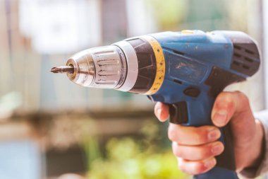 Bunu kendin yap. Tamirci elinde kablosuz bir tornavida tutuyor.