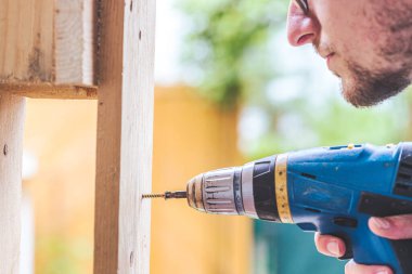 Bunu kendin yap. Tamirci vida için kablosuz tornavida kullanıyor.