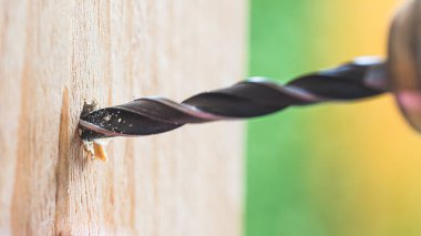 Kendin yap. Tamirci ahşap delmek için matkap kullanıyor.