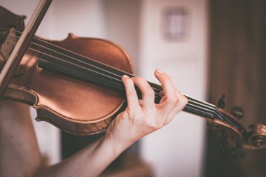 Genç kız kemanıyla, akustik müziğiyle pratik yapıyor.