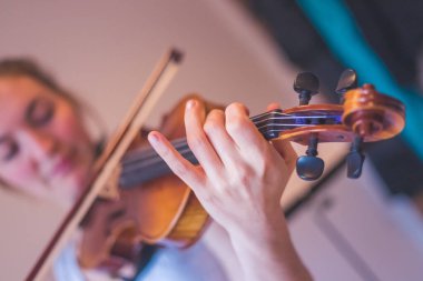 Genç kız kemanıyla, akustik müziğiyle pratik yapıyor.
