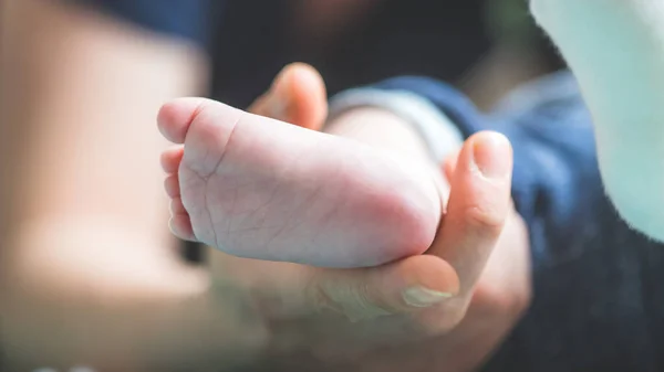 Acercamiento Las Manos Madre Sosteniendo Los Pies Del Bebé Recién —  Fotos de Stock