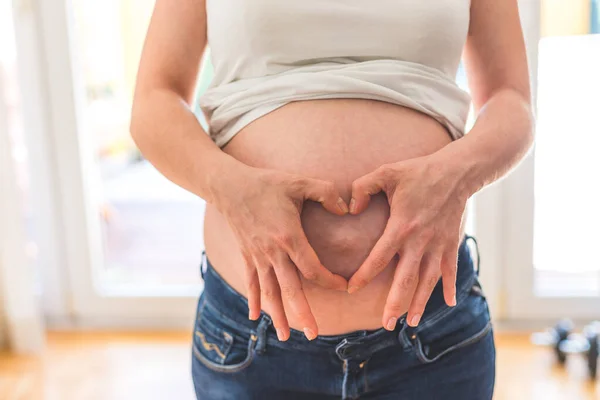 幸せな白人妊娠中のお母さんタッチ彼女の裸のおなか ブルージーンズ 閉じます — ストック写真