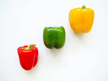 Kırmızı, yeşil ve sarı dolmalık biberler stüdyoda beyaz arka planda izole edilmiş.