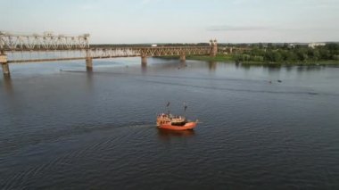 Güneşli bir havada, sakin sularda yelken açan gemi, uçan insansız hava aracının güzel 4K panoramik hava görüntüsüdür.