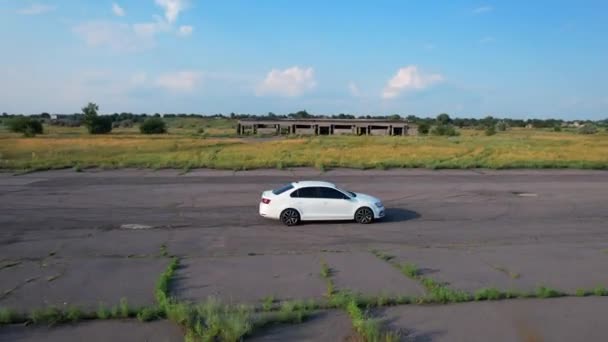 白い車が道路を進んでいる。ドローンは車に従っている。ウクライナのPoltavska obrest, 25.07.2021 — ストック動画