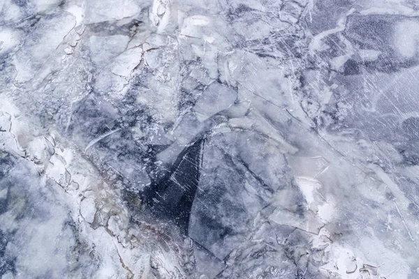 Texture of ice floe surface with hole and cracks.Winter background