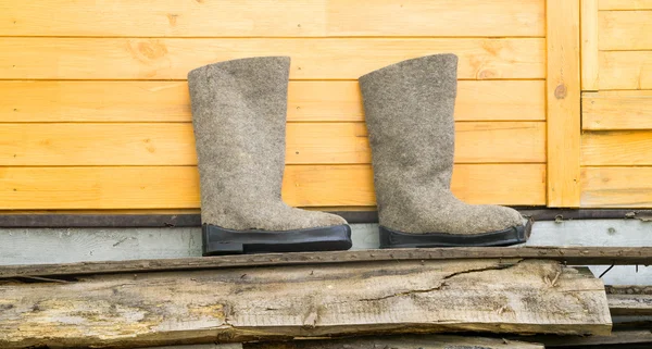 Felt boots near wooden wall