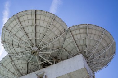 Arka plan gökyüzü üzerinde çanak antenler