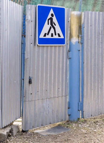 Metal gate with road sign pedestrian crossing