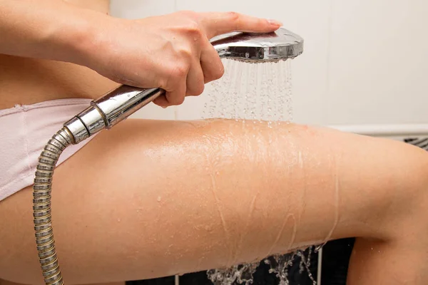 Girl Hand Holds Shower Washes Scrub Her Thigh Water — стоковое фото