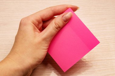 Sol kadın eli notlar için pembe notlar tutuyor.