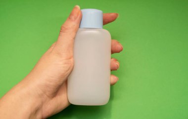 Çerçevenin ortasındaki sol kadın elinde kapalı mavi deterjan kutusu var.