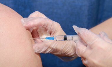 Doktorun elleri aşıyı hastanın omzuna yapıyor.