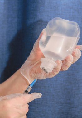 Eller temiz eldivenlerde, tuz çözeltisini tut ve şırınganın içine çek.