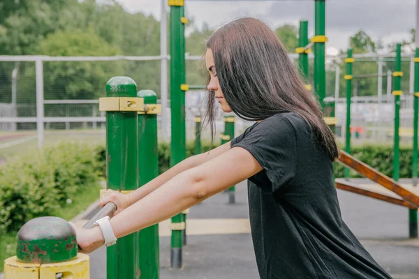 Siyah Tişörtlü Taytlı Bir Kız Oyun Parkındaki Yatay Bardan Elini — Stok fotoğraf