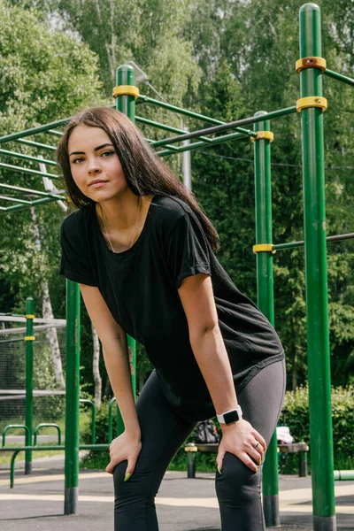 Uma Menina Uma Camiseta Preta Leggings Mantém Suas Mãos Seu — Fotografia de Stock