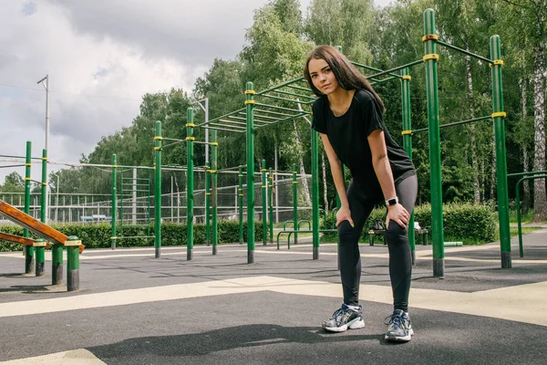 Uma Menina Uma Camiseta Preta Leggings Mantém Suas Mãos Seu — Fotografia de Stock