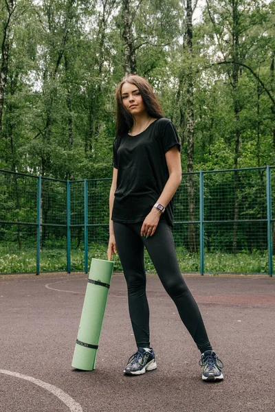 Siyah Tişörtlü Taytlı Bir Kız Spor Sepetinin Üzerinde Duruyor — Stok fotoğraf
