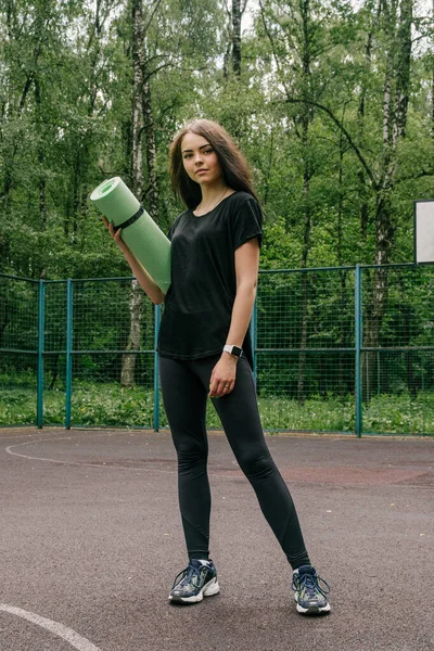 Siyah Tişörtlü Taytlı Bir Kız Spor Sepetinin Üzerinde Duruyor — Stok fotoğraf