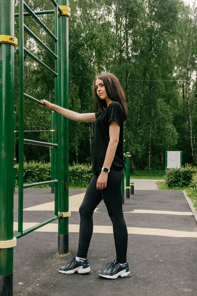 Menina Uma Camiseta Preta Leggings Esticando Nas Escadas — Fotografia de Stock