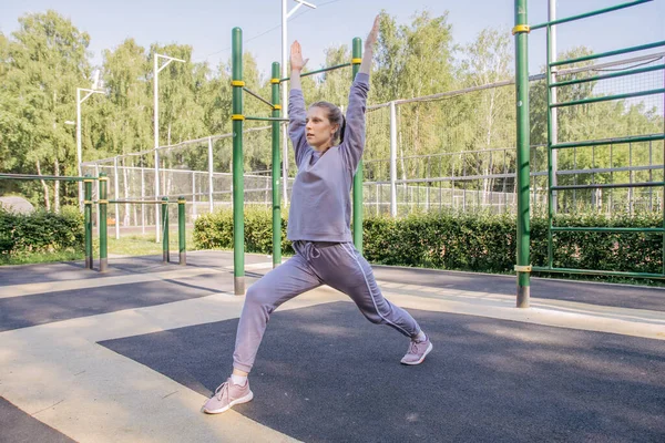 Uma Menina Fones Ouvido Uniforme Esportivo Playground Realiza Exercício Alongamento — Fotografia de Stock