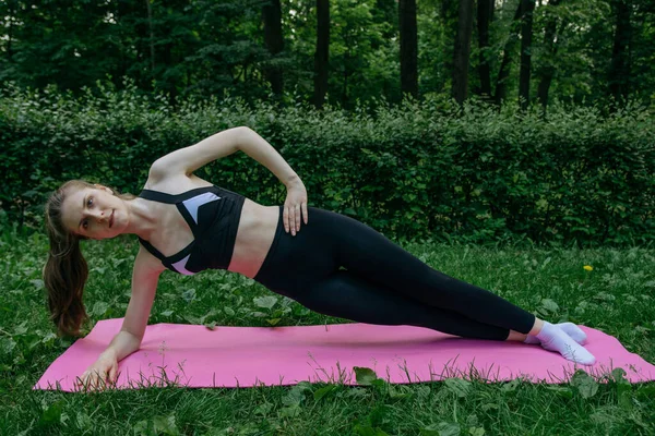 Uma Menina Sutiã Esportivo Leggings Pretos Tapete Rosa Gramado Verde — Fotografia de Stock