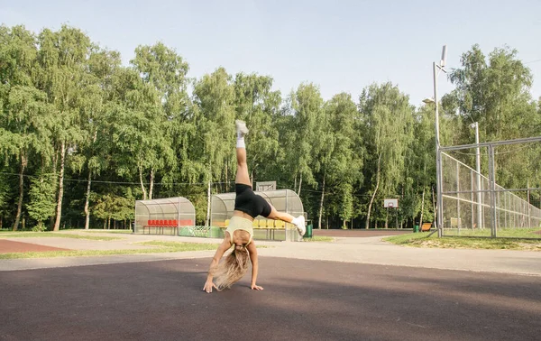 Çocuk Parkında Spor Üniformalı Sarışın Bir Kız Egzersiz Tekeri Yapıyor — Stok fotoğraf