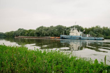 08 / 21 / 2021 Rusya, Kolomna. Eski paslı bir mavna yazın Moskova Nehri 'nden geçiyor.