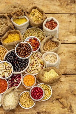 Değişik fasulye ve tahıl çeşitleri. Sağlıklı bir yaşam tarzı için vazgeçilmez protein kaynakları. Eski tahta arka plan, üst görünüm