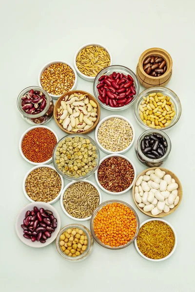 豆や穀物の異なる種類を割り当てます 健康な生活のためのタンパク質の不可欠な源のセット ライトグリーンの背景 トップビュー — ストック写真