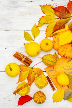 Alkolsüz portakal kokteyli. Bayramlık Cadılar Bayramı içeceği, dekoratif balkabakları, dökülen yapraklar ve tarçın çubukları. Beyaz tahta tahta arka plan, üst görünüm