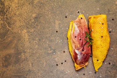 Çiğ ördek göğsü, deniz tuzu, taze biberiye ve karabiberli mısır. Kümes hayvanları, doğal BIO ürünü, evcil kümes hayvanı. Taş beton zemin, üst görünüm