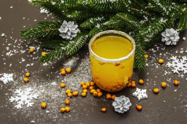 Taze deniz dikenli meyveli düşük alkollü meyve kokteyli. Noel ya da yeni yıl tatlı içeceği, köknar dalları. Siyah taş arkaplan, boşluğu kopyala